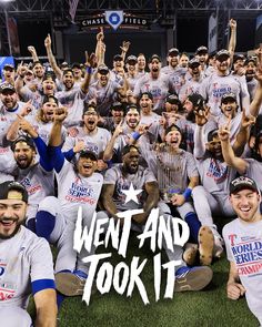 a group of baseball players holding up their hands in the air and posing for a photo