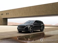 a black suv is parked in front of a large building with a bridge above it