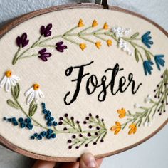 a hand embroidered sign with flowers and the word foster