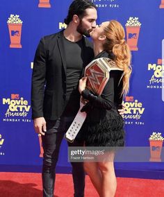 two people kissing on the red carpet at an awards event in las angeles, california