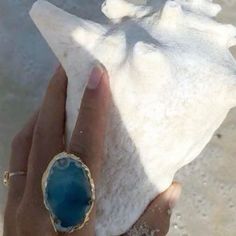 a person holding a piece of white sand with a blue stone in it