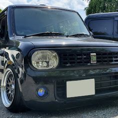 the front end of a black van parked in a parking lot next to another vehicle