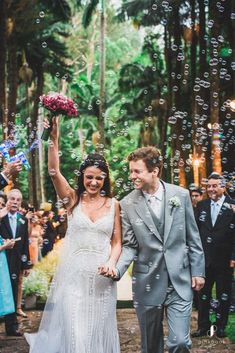 a newly married couple walking down the aisle with bubbles in the air as they exit their wedding ceremony