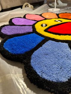 a multicolored flower shaped rug on top of a table