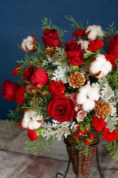 a basket filled with lots of red and white flowers