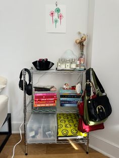 a shelf with many books and purses on top of it in a living room