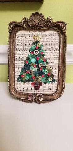 a christmas tree made out of buttons in a frame