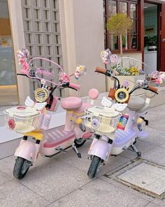 two pink mopeds parked on the side of a street next to each other