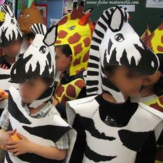 several children in animal costumes are eating and looking at the same person's face