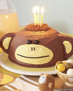 a birthday cake decorated with a monkey face and candles