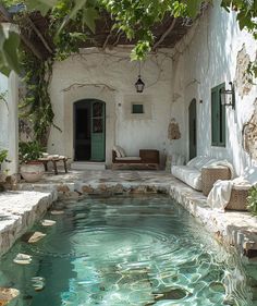 an outdoor swimming pool surrounded by greenery and stone walls with doors leading to the outside