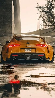 an orange sports car is parked on the side of the road with its rear lights on