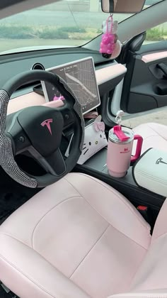 the interior of a car with pink leather seats and steering wheel, cup holder, coffee mug and laptop