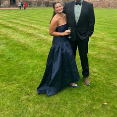 a man and woman in formal wear posing for a photo