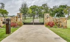 a gated driveway leading into a lush green park