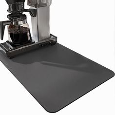 a coffee maker sitting on top of a mat