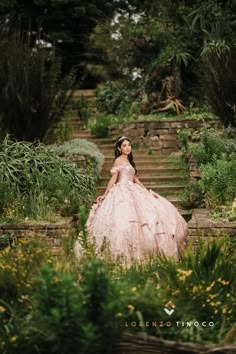 a woman in a pink dress sitting on some steps