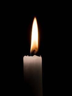 a lit candle in the dark with one light on it's side and another burning