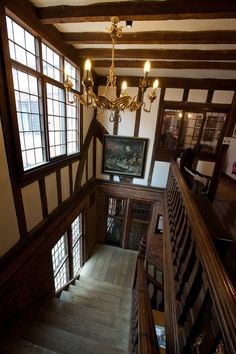 an old house with wooden stairs and chandelier