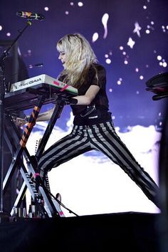 a woman in striped pants standing at a keyboard