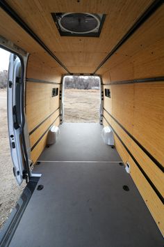 the inside of a van with wood paneling and white toilet paper on the floor