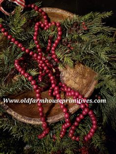 red berries are hanging from the branches of a christmas tree with an american flag in the background