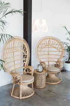 rattan chairs and stools are arranged in front of a neon sign that reads love