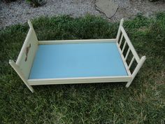 a small wooden bed frame sitting in the grass