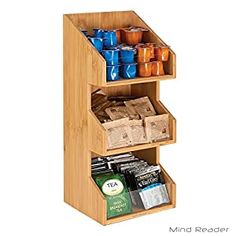 a bamboo spice rack with three compartments filled with teas and coffee bags on it