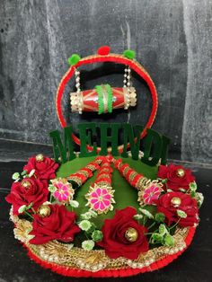 an elaborately decorated hat with flowers and beads sits on top of a black surface