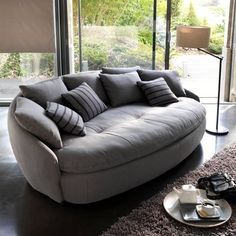 a couch sitting in front of a window next to a table with plates on it