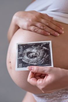 a pregnant woman's belly is shown with an identification card in front of her stomach