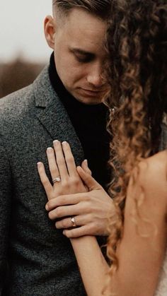 a man in a suit and tie holding his hand on the woman's shoulder