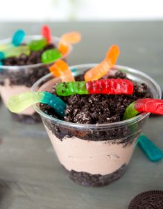 two dessert cups filled with dirt and gummy bears