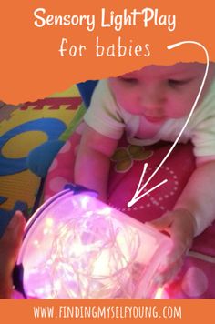 a baby is playing with some lights on her chest and the words, sensory light play for babies