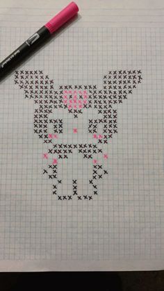 a cross stitch pattern with a cat on it and a pink marker next to it