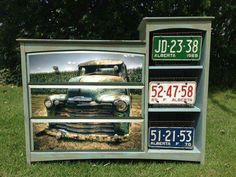 an old truck painted on the side of a book shelf with two license plates attached to it