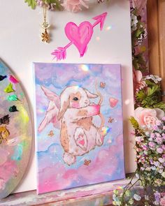 a painting on a wall next to some flowers and other art work with pink hearts