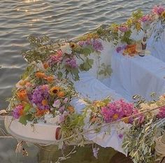 a boat with flowers on it floating in the water