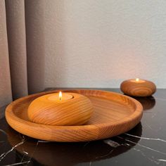 two wooden candles are sitting on a black table