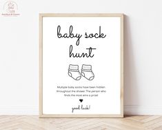 a baby sock hunt poster on the wall next to a wooden frame with a black and white background