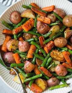 a white bowl filled with potatoes and green beans on top of a striped table cloth