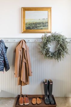 a coat rack with shoes and coats hanging on it