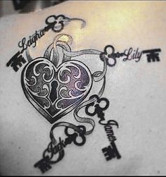 the back of a woman's shoulder with keys and a heart tattoo