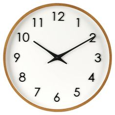 a white clock with black numbers on the face is shown against a white background and shows 11 o'clock