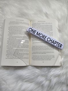 an open book with the word one more charter on it laying on a fluffy white surface