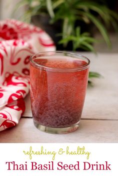 a glass filled with red liquid sitting on top of a table