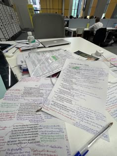 several pieces of paper with writing on them sitting on top of a desk in an office