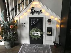 a dog house is decorated with wreaths and lights for the welcome sign to your home