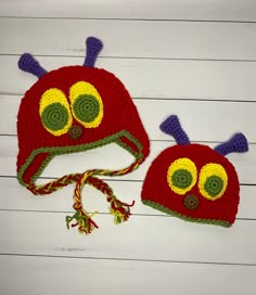 two crocheted hats with eyes and antennae